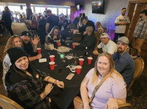 Fans at a table enjoying the show posing for a photo